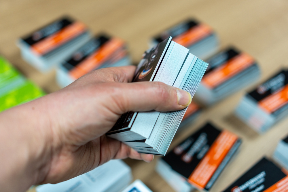 A,worker's,hand,holding,a,package,of,printed,business,cards