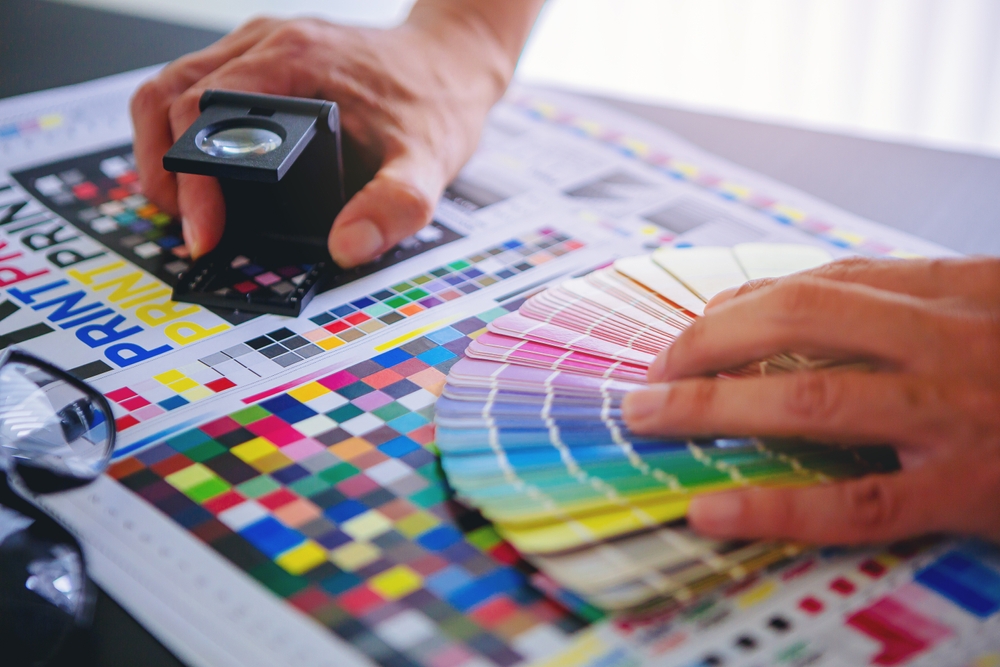 Crop,image,of,worker,checking,print,quality,of,media,graphics